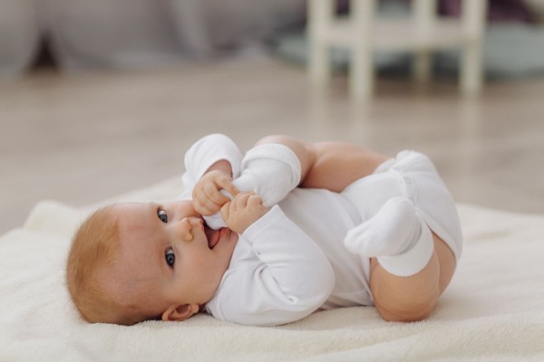 Un bébéallongé se mange un pied